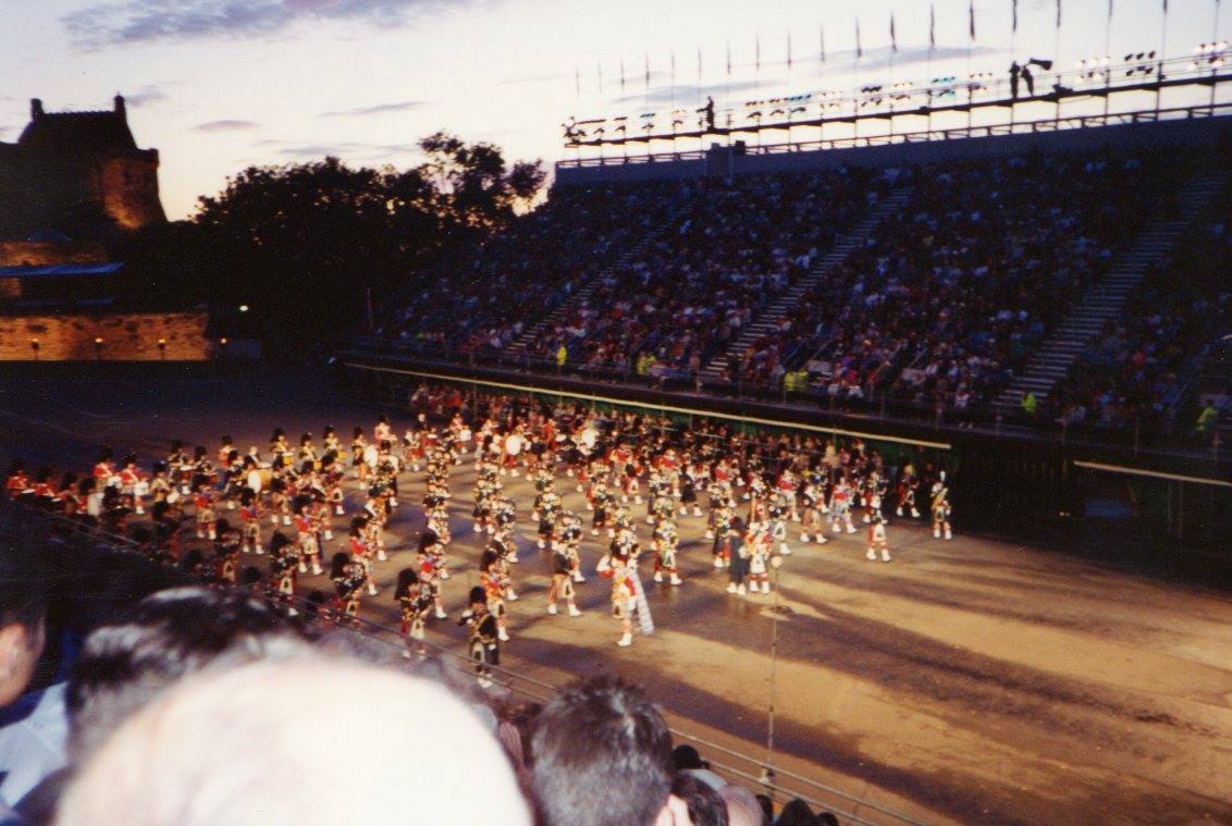 Massed pipe bands marching at Edinburgh Castle's floodlit esplanade