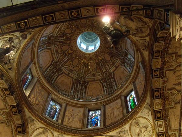 Baroque carved wooden dome with stained glass windows and glowing lantern