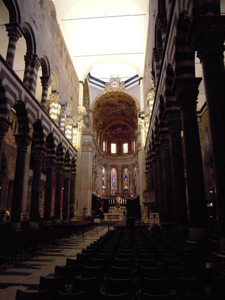 Inside Genoa Cathedral: striped columns, gilded apse and stained glass