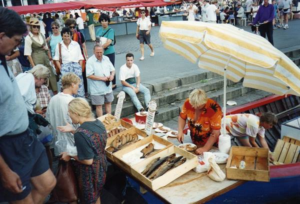 Fish stall at Bergen fish market, fish in wooden crates, yellow striped umbrella
