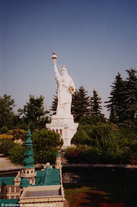 Miniature Statue of Liberty replica surrounded by pine trees and model buildings