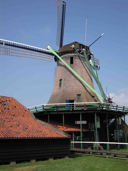 Brick windmill with wooden sails and red tile roofs at Zaanse Schans