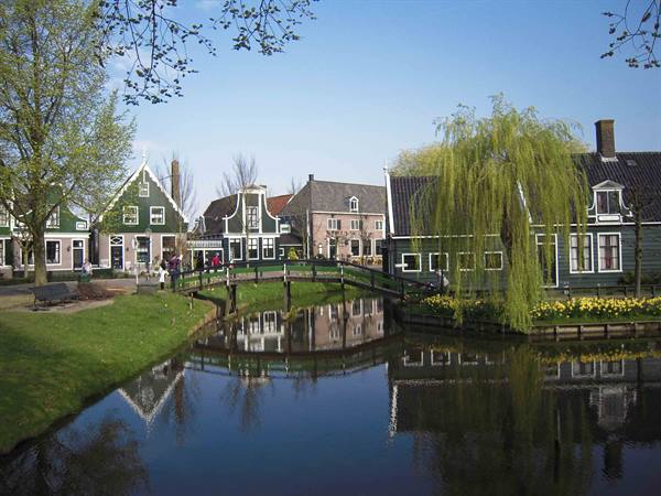 Green wooden houses along a canal with a bridge, Zaanse Schans