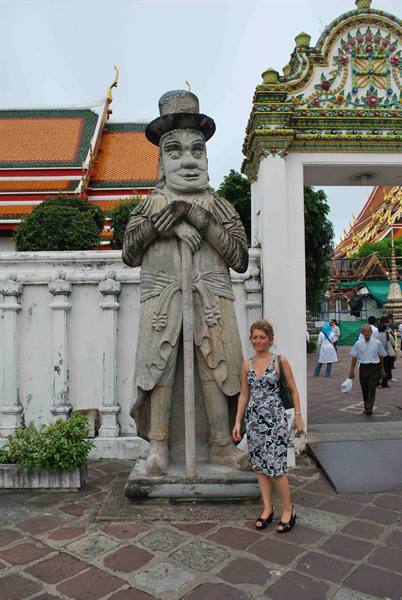 Tourist beside the stone statue of the top-hatted European, Wat Pho