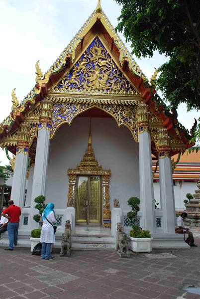 Tourists in front of a golden pavilion at Wat Pho, Bangkok