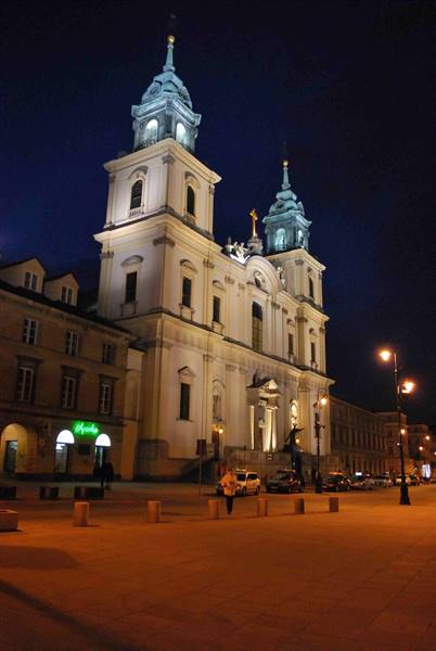 Holy Cross Church in Warsaw lit at night, baroque facade with two towers