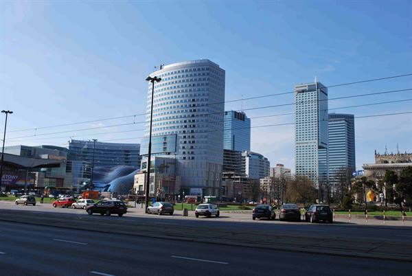 Glass skyscrapers and traffic under blue sky in Warsaw