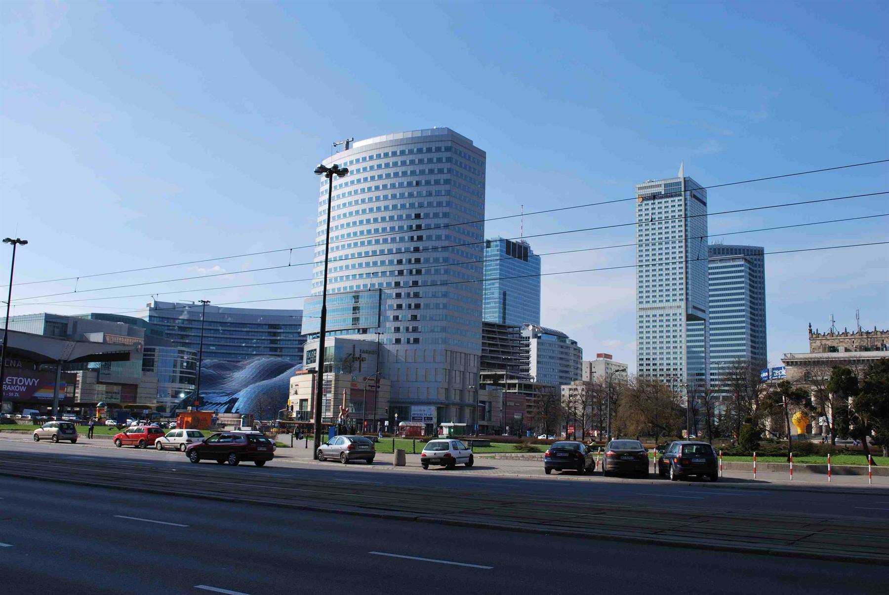 Glass skyscrapers and traffic under blue sky in Warsaw