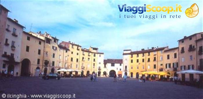Piazza dell'Anfiteatro in Lucca, colorful buildings, umbrellas and people under blue sky