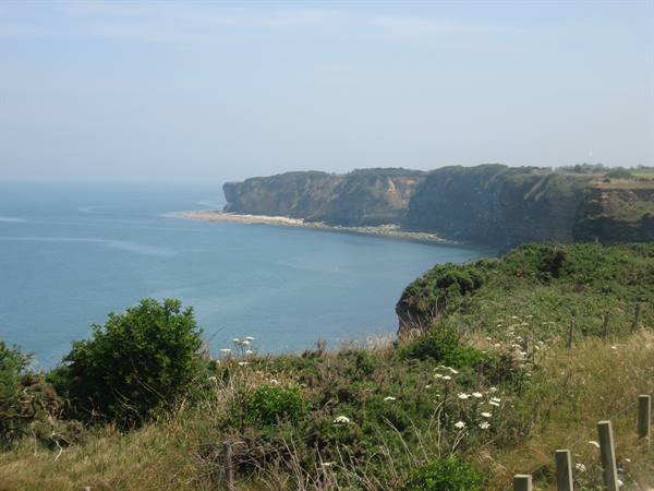 Limestone cliffs over calm sea at Pointe du Hoc, Normandy
