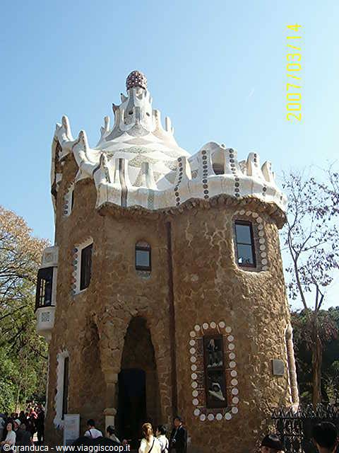 Stone gatehouse with white mosaic roof at Parc Güell, Barcelona