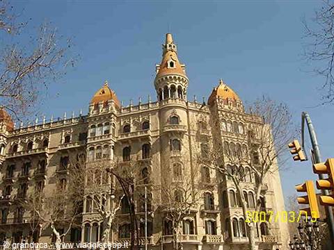 Casa de les Punxes in Barcelona, brick facade with conical towers under blue sky