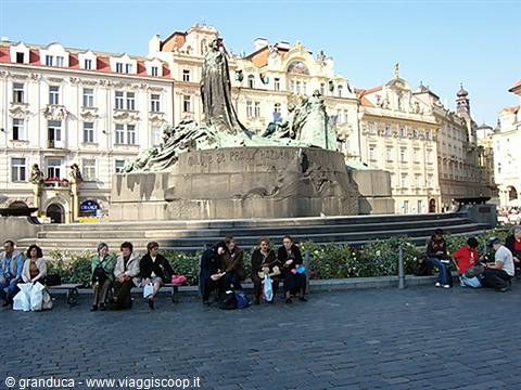 Tourists sitting in front of the Jan Hus monument in Prague