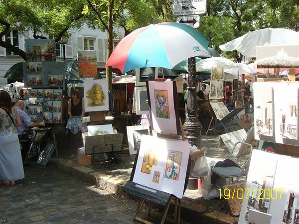 Painters with easels and paintings under umbrellas at Place du Tertre