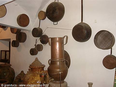 Copper pots and pans hanging on white wall, old kitchen tools