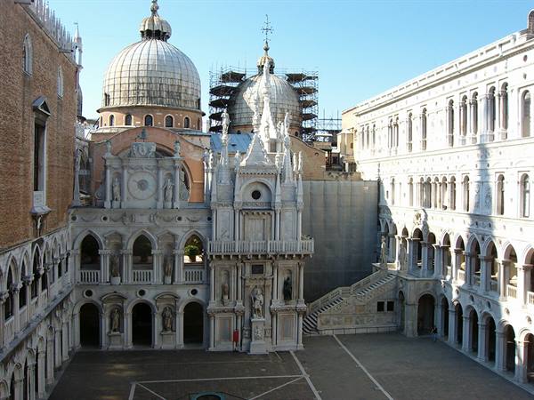 Doge's Palace courtyard in Venice, white marble, domes and scaffolding under sunlight