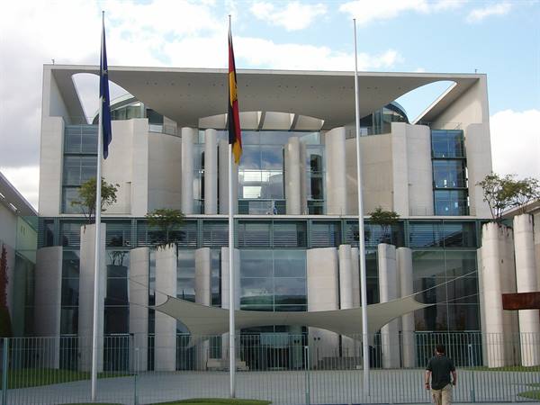 Berlin Chancellery building, glass and light stone facade, German and EU flags