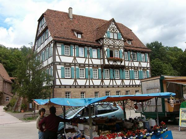 Market stalls in front of half-timbered house with green shutters, Maulbronn