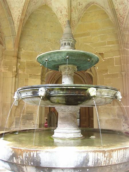 Two-tiered stone and bronze fountain inside Maulbronn cloister