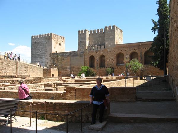 Tourist in front of the crenellated towers of the Alcazaba of Málaga in sunshine