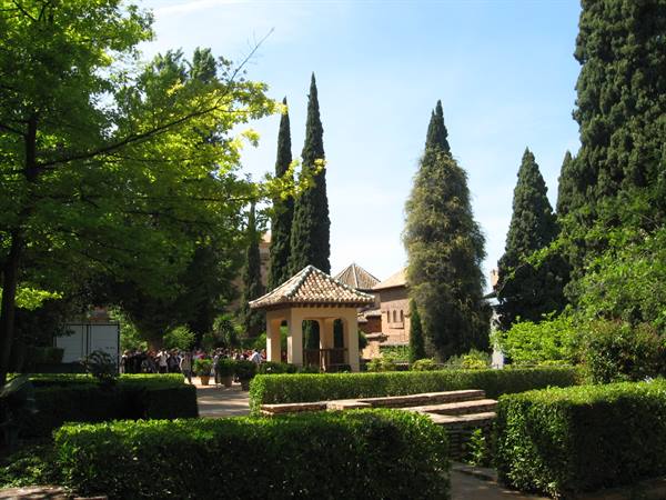 Tiled pavilion among cypresses and hedges in the Alhambra gardens