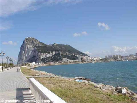 The Rock of Gibraltar seen from the paved seaside promenade, midday light