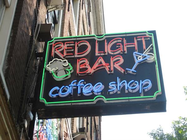 Neon sign of Red Light Bar coffee shop on a brick facade, Amsterdam