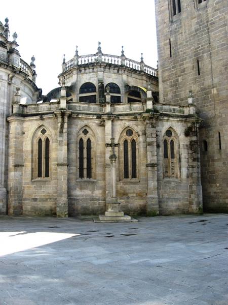 Granite cathedral with Gothic apse windows and stone cross in square