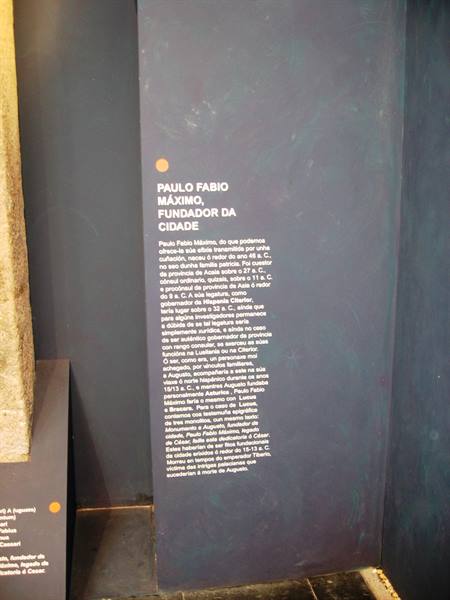 Museum panel about Paulo Fabio Maximo, city founder, beside ancient stone