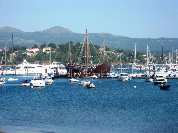 Wooden ship moored among yachts and boats at Baiona harbor
