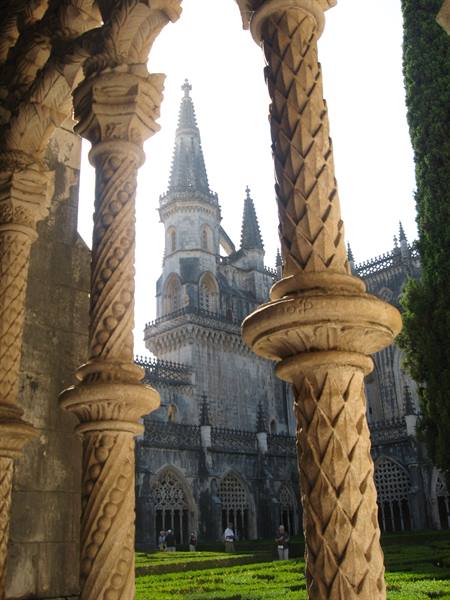 Carved stone columns frame the gothic cloister of Batalha monastery and its spires