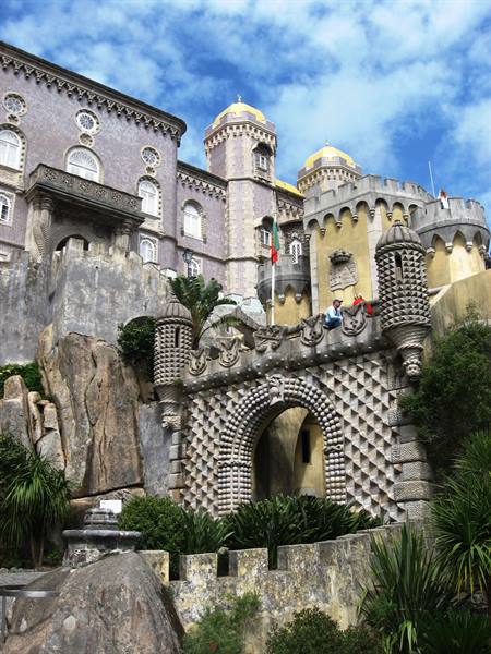 Pena Palace in Sintra, crenellated towers and ornate arch among rocks and plants