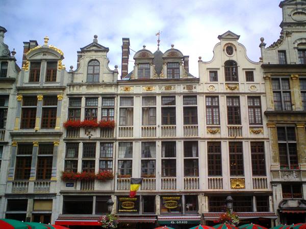 Ornate baroque guildhalls on Brussels' Grand-Place, colorful umbrellas in foreground