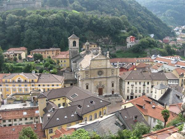The Collegiate church of Bellinzona among red roofs and castles on green hills