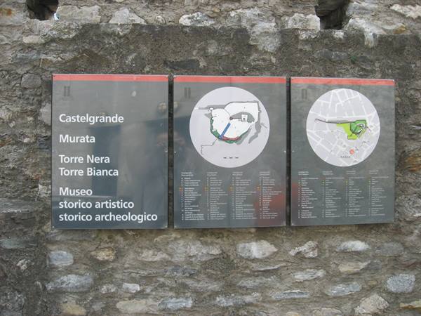 Information panels on stone wall: museum and Castelgrande, Bellinzona