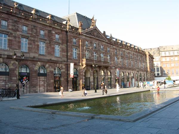People beside the fountain on Place Kléber, in front of the sandstone Aubette
