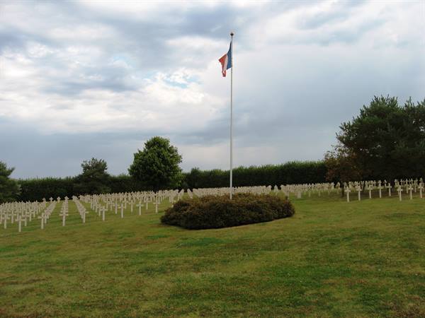 Military cemetery with white crosses and French flag at center