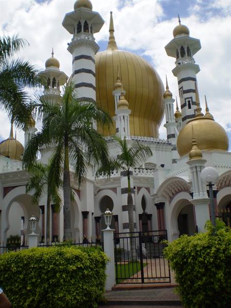 Ubudiah Mosque in Kuala Kangsar, golden domes and white minarets among palms