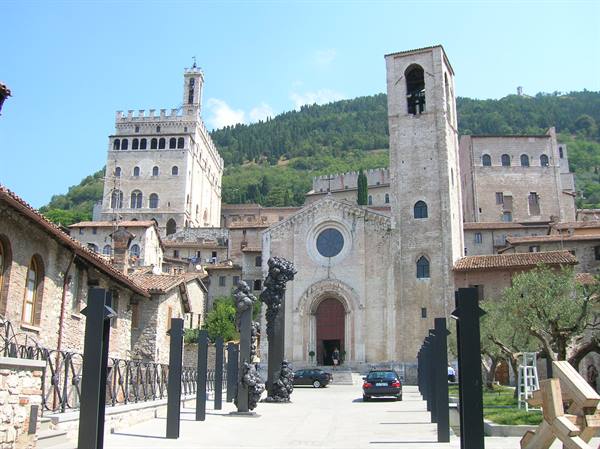 Piazza Grande in Gubbio: stone cathedral and Palazzo dei Consoli beneath the hill
