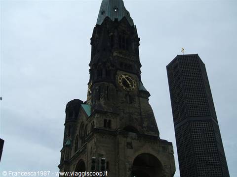Kaiser Wilhelm Memorial Church in Berlin: damaged stone tower beside dark skyscraper