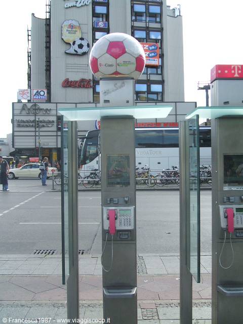 Telephone booths topped with a soccer ball, busy street with buses and bicycles, Berlin