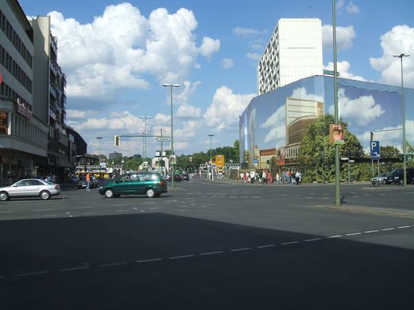 Berlin: crossing with cars and a building wrapped in cloudy print