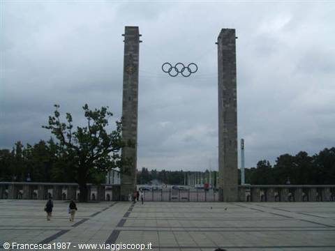 Olympic rings suspended between two stone pillars, Berlin Olympiastadion, grey sky