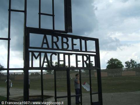 Iron gate bearing the inscription Arbeit macht frei, Sachsenhausen memorial, under cloudy sky