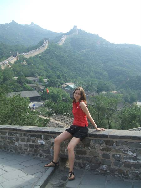 Woman in red top sitting on the stone wall of the Great Wall