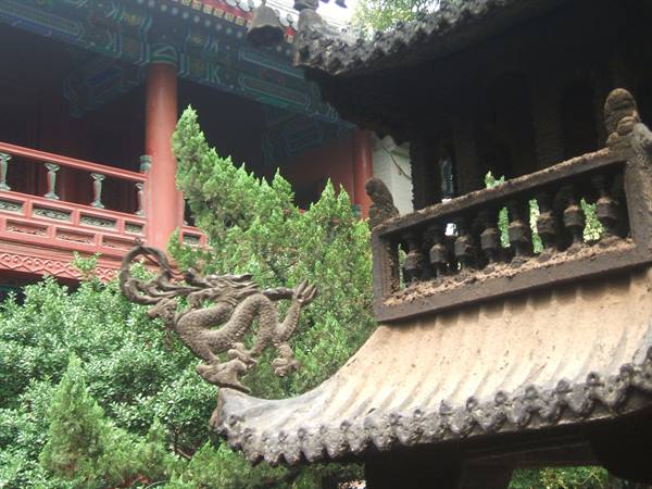Red pavilion and iron roof with sculpted dragon at Buddhist temple