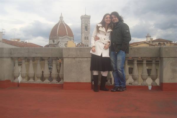 Couple embracing on a terrace, Florence Duomo and bell tower behind