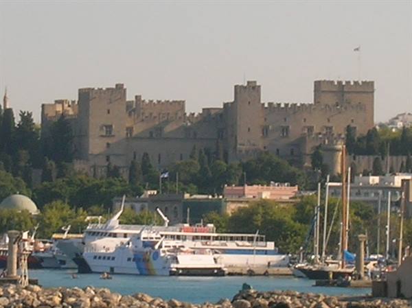 The Palace of the Grand Master in Rhodes above the harbour with docked ferries