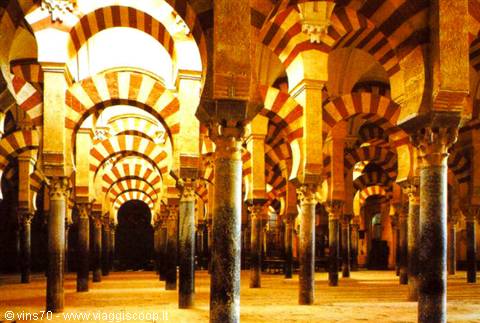 Red and white double arches of the Mezquita in Cordoba, marble columns in warm light