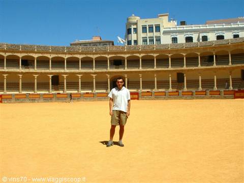 Tourist standing on the sand inside a bullring arena